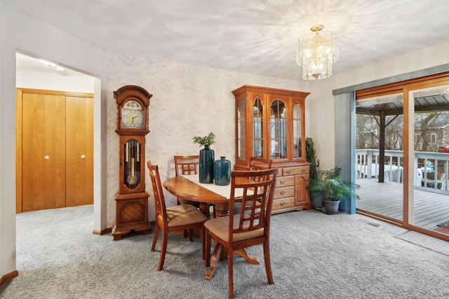 carpeted dining room featuring an inviting chandelier