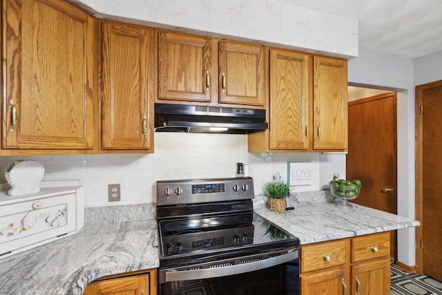 kitchen with light stone counters, decorative backsplash, and range with electric cooktop