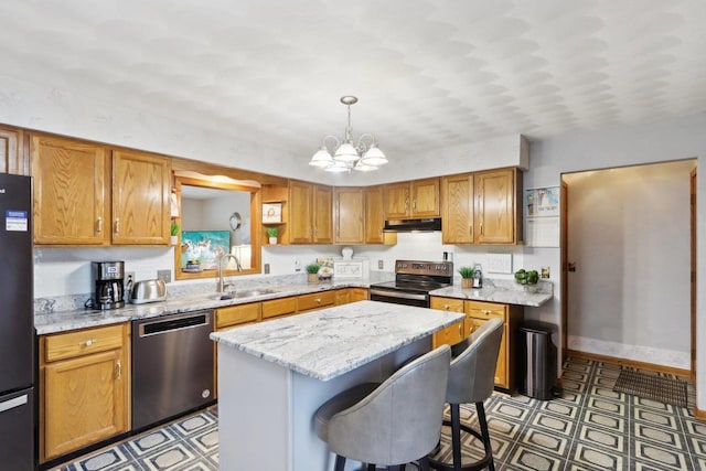 kitchen with sink, a breakfast bar, appliances with stainless steel finishes, hanging light fixtures, and a center island