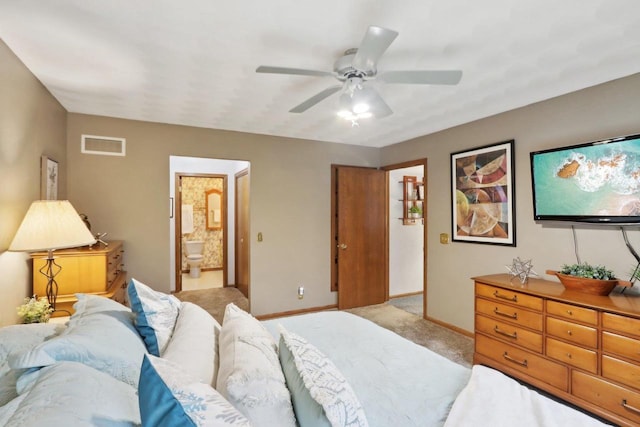 bedroom featuring connected bathroom, light colored carpet, and ceiling fan