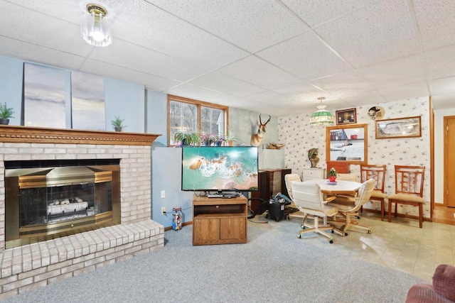 living room featuring a fireplace and a paneled ceiling