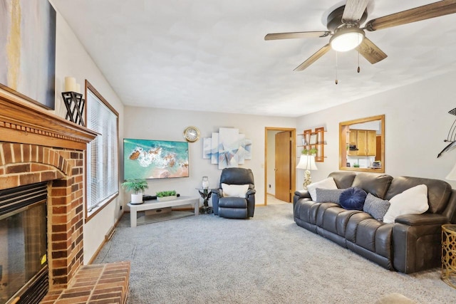 carpeted living room with ceiling fan and a brick fireplace