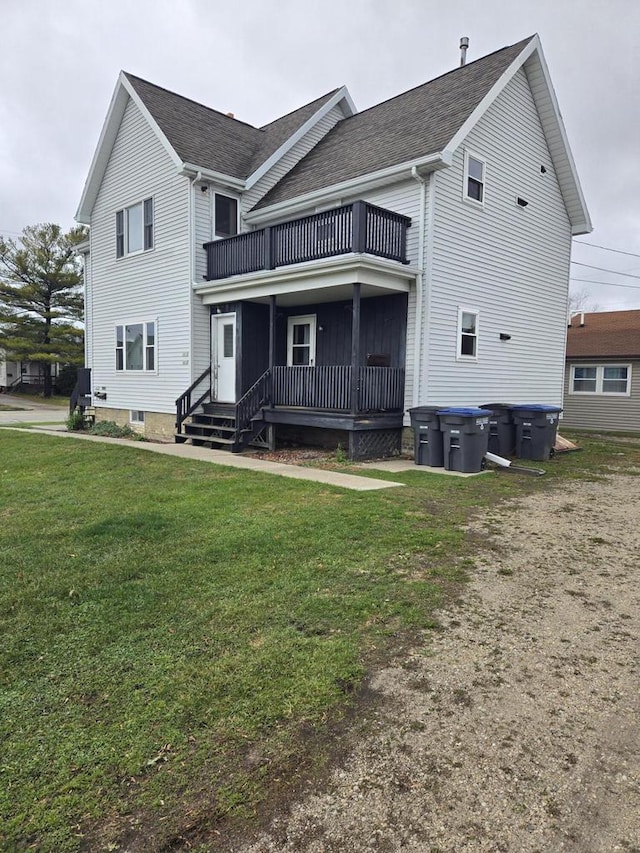 back of house with a balcony and a lawn