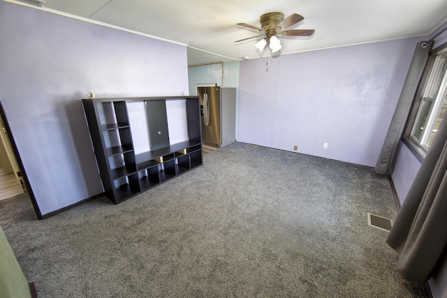 unfurnished living room featuring dark colored carpet and ceiling fan