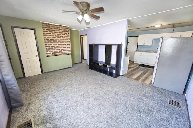 interior space featuring light colored carpet, stainless steel fridge, and ceiling fan