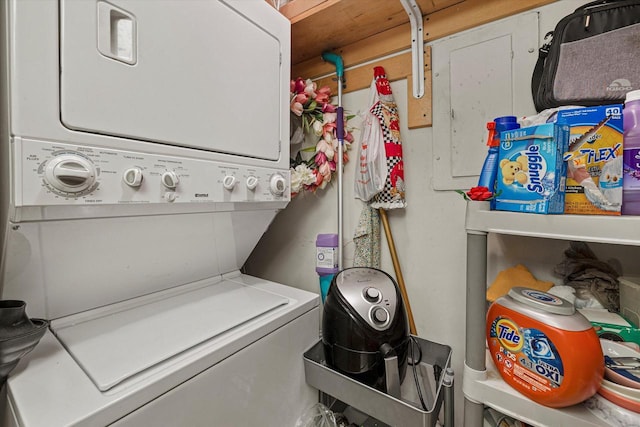 clothes washing area featuring stacked washing maching and dryer