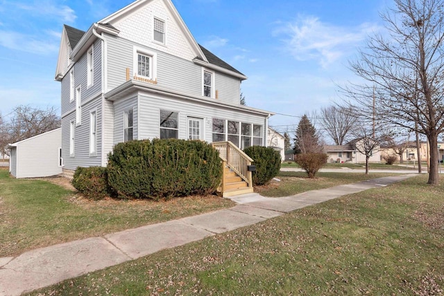 view of front of house featuring a sunroom and a front lawn