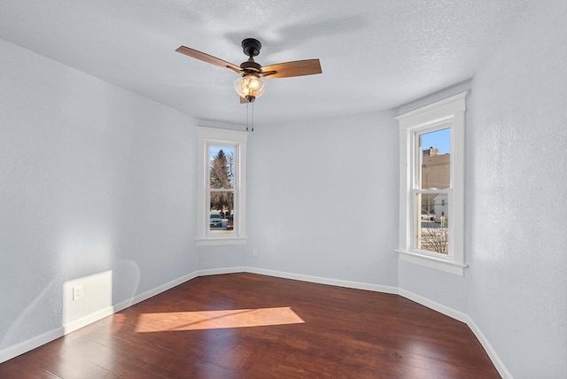 empty room featuring a textured ceiling, dark hardwood / wood-style floors, and ceiling fan