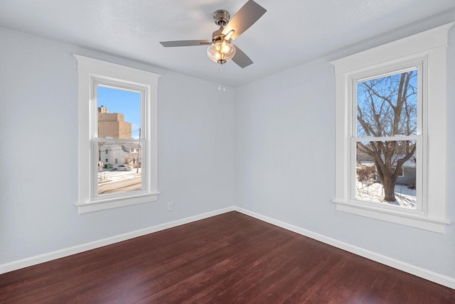 empty room with ceiling fan and dark hardwood / wood-style flooring