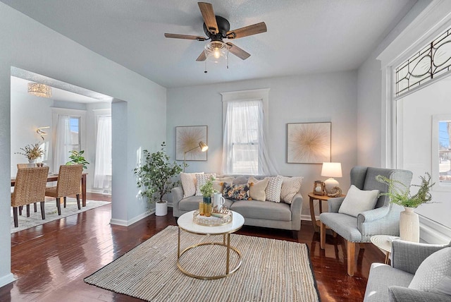 living room with ceiling fan and dark hardwood / wood-style flooring