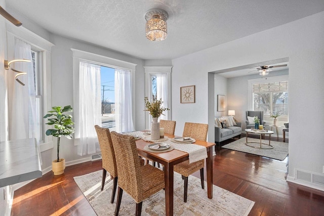 dining area with dark wood-type flooring and a textured ceiling