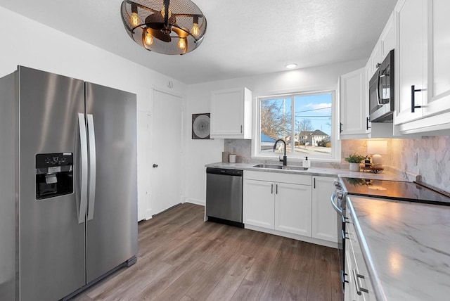 kitchen with stainless steel appliances, sink, white cabinets, and a textured ceiling