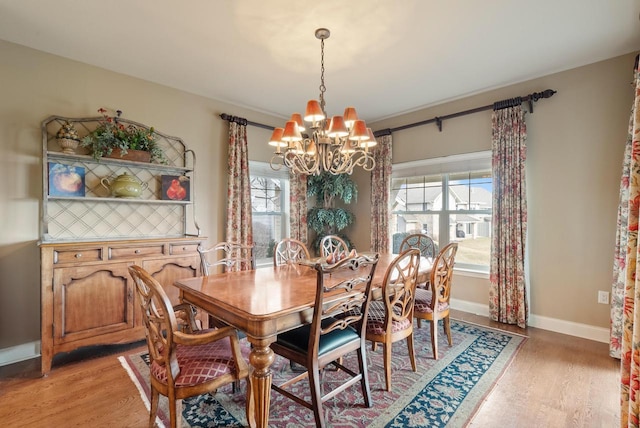 dining space with hardwood / wood-style flooring and an inviting chandelier