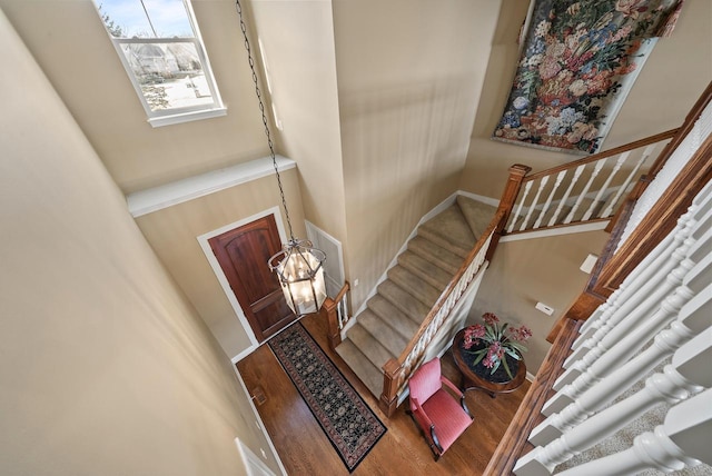 entrance foyer with a towering ceiling, hardwood / wood-style floors, and a notable chandelier