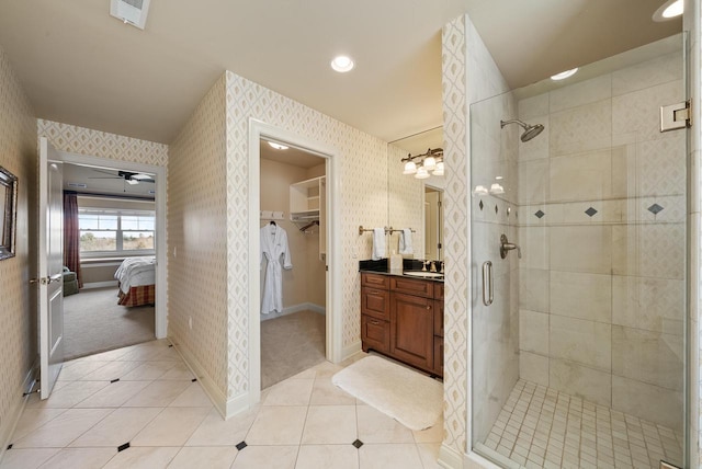 bathroom with walk in shower, ceiling fan, vanity, and tile patterned flooring