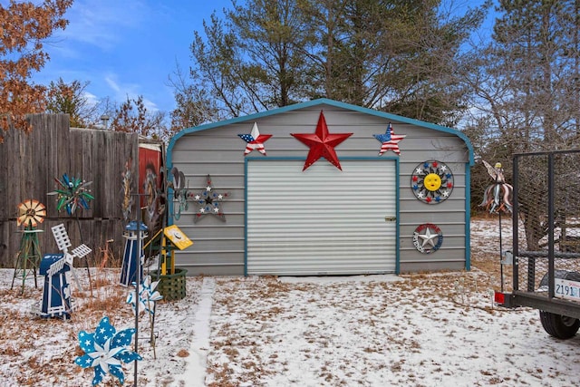 snow covered structure with a garage