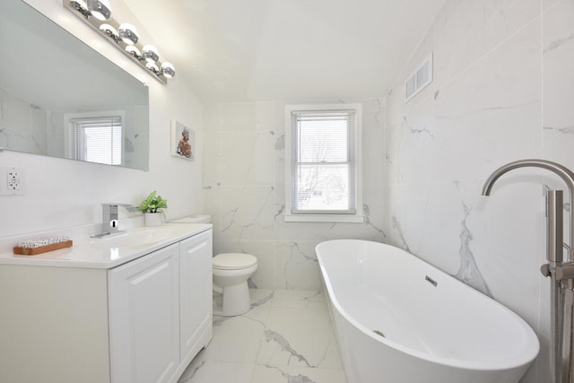 bathroom with a bathing tub, tile walls, vanity, and toilet