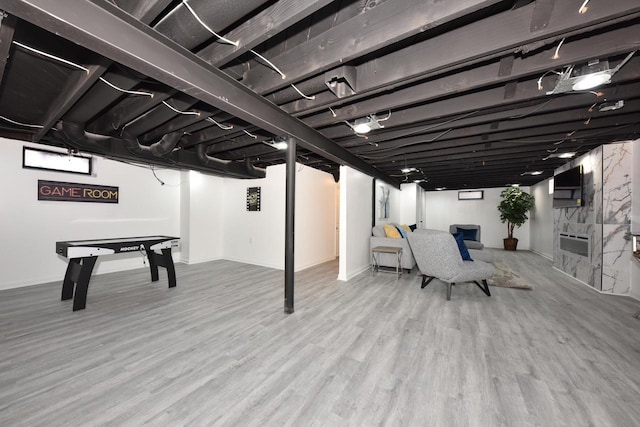 basement featuring wood-type flooring and a fireplace