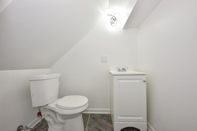 bathroom with vanity, lofted ceiling, and toilet