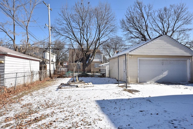 yard covered in snow with an outbuilding and a garage