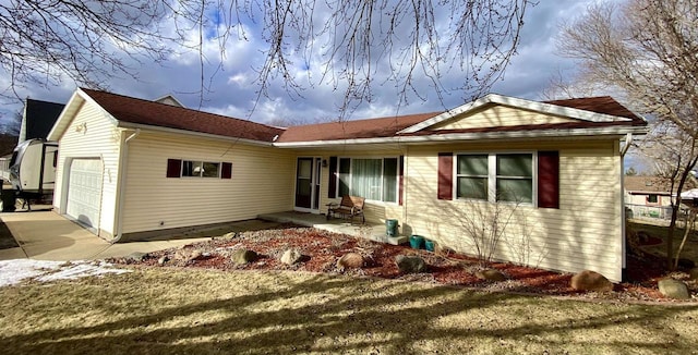 back of house with a garage and a yard