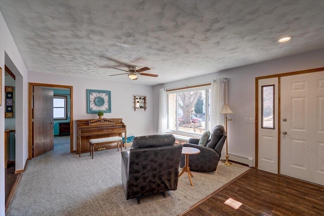 living room with wood-type flooring, a healthy amount of sunlight, a textured ceiling, and baseboard heating