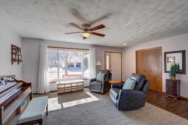 sitting room with ceiling fan, dark hardwood / wood-style flooring, a textured ceiling, and a baseboard radiator