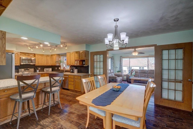 dining area featuring sink, a chandelier, and dark hardwood / wood-style flooring