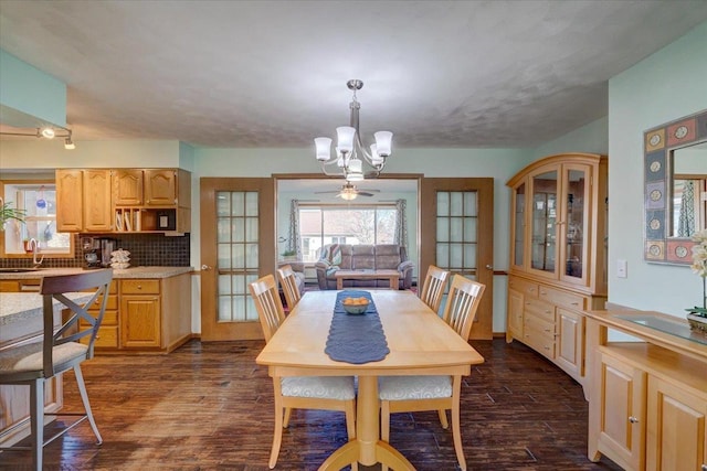 dining room featuring dark hardwood / wood-style flooring, sink, and a chandelier