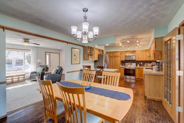 dining space featuring ceiling fan with notable chandelier and dark wood-type flooring