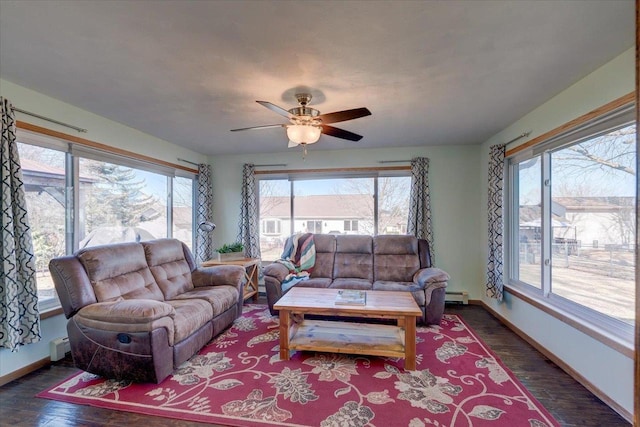 living room with dark wood-type flooring, ceiling fan, plenty of natural light, and a baseboard radiator