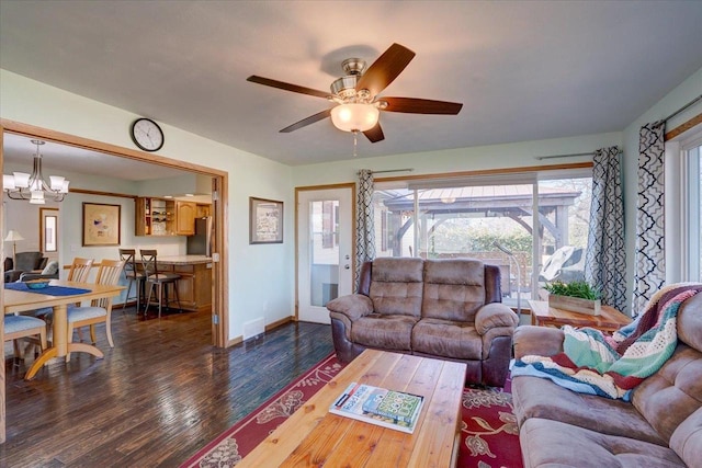 living room with dark hardwood / wood-style flooring and ceiling fan with notable chandelier