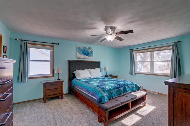 bedroom featuring multiple windows, light carpet, and ceiling fan