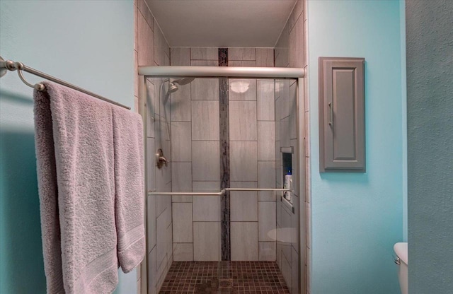 bathroom with an enclosed shower and toilet