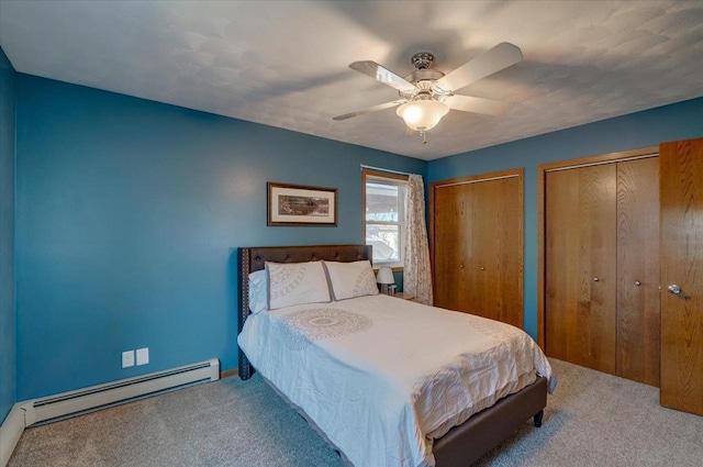 carpeted bedroom featuring multiple closets, ceiling fan, and a baseboard heating unit