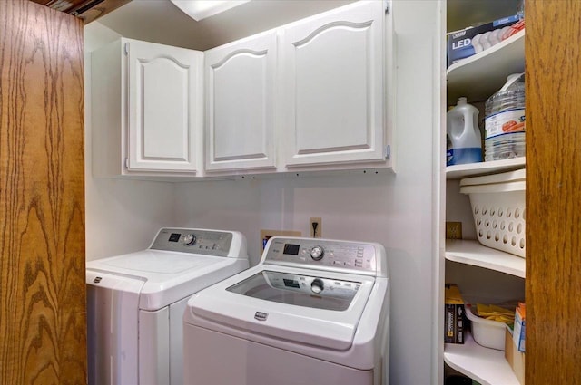 clothes washing area featuring cabinets and separate washer and dryer