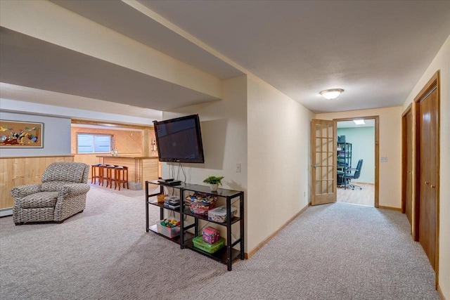 hallway with carpet flooring, wooden walls, and french doors