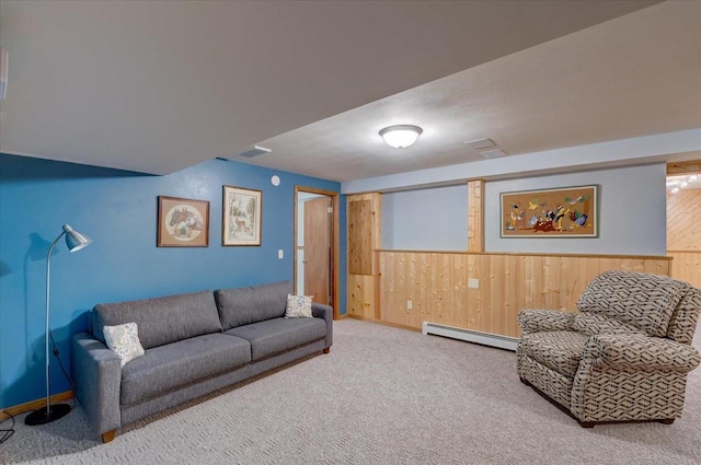 living room featuring a baseboard radiator, wooden walls, and carpet flooring