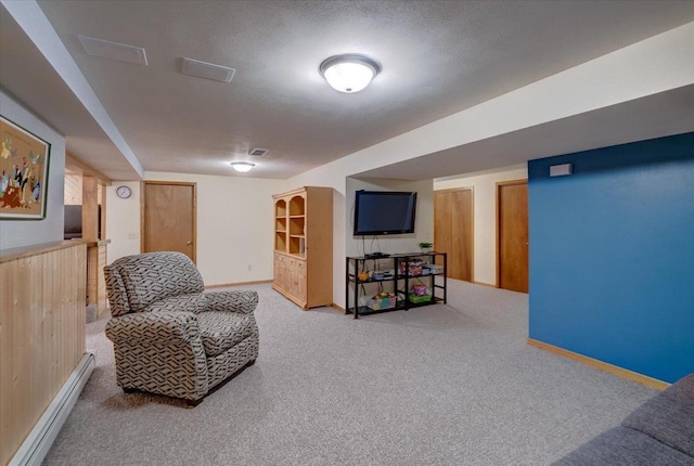 sitting room featuring carpet floors, a textured ceiling, and baseboard heating