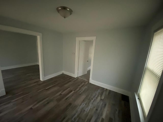 spare room with dark wood-type flooring