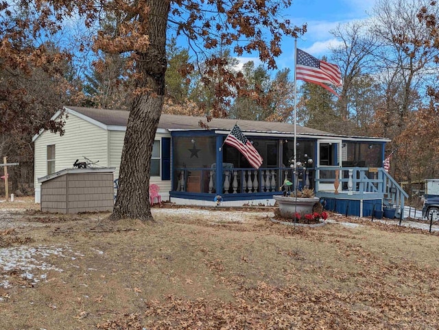 rear view of house with a lawn and a sunroom