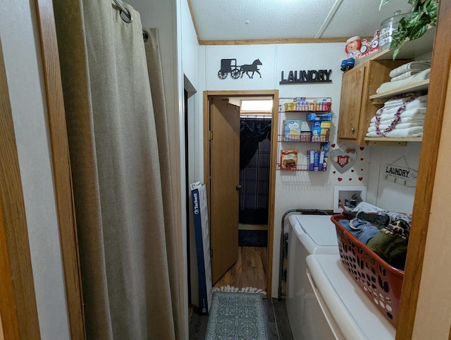 clothes washing area featuring washer and clothes dryer, cabinets, and a textured ceiling