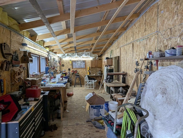 miscellaneous room featuring lofted ceiling and a workshop area