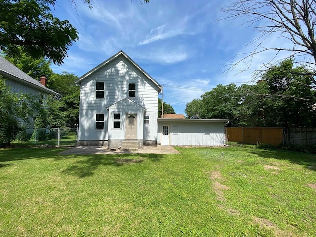 rear view of property featuring a lawn and a patio area