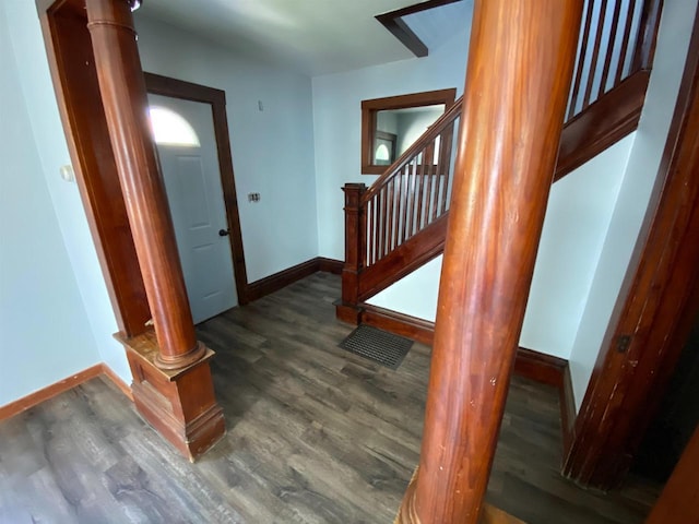 stairway featuring wood-type flooring and ornate columns