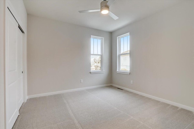 unfurnished bedroom with ceiling fan, a closet, and light carpet