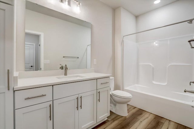 full bathroom with hardwood / wood-style flooring, shower / washtub combination, toilet, and vanity