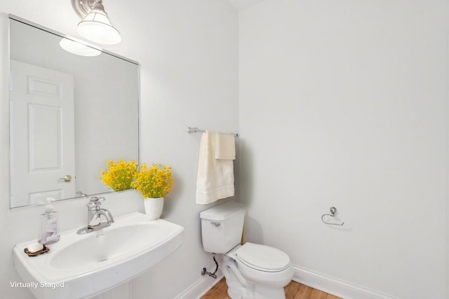 bathroom with hardwood / wood-style flooring, toilet, and sink