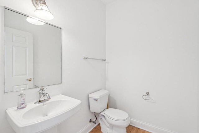 bathroom featuring hardwood / wood-style flooring, toilet, and sink