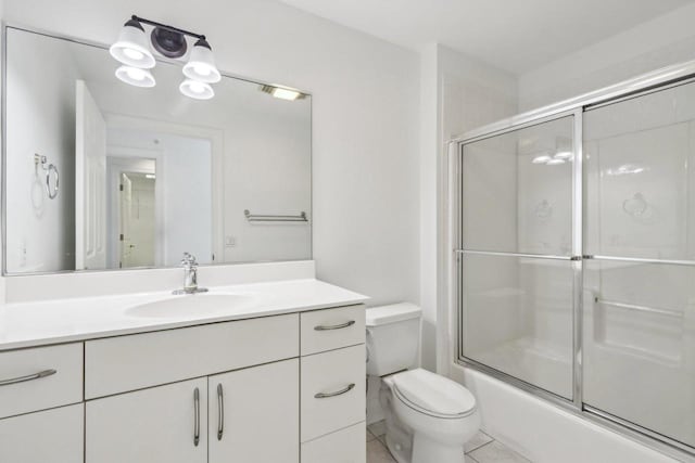 full bathroom featuring vanity, tile patterned flooring, bath / shower combo with glass door, and toilet